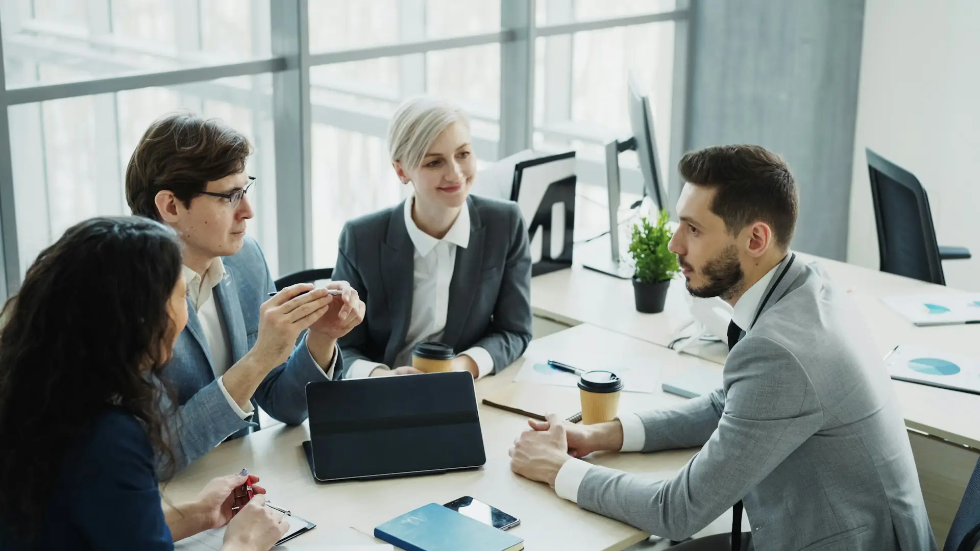 Business team discussing a project around a table in a bright modern office